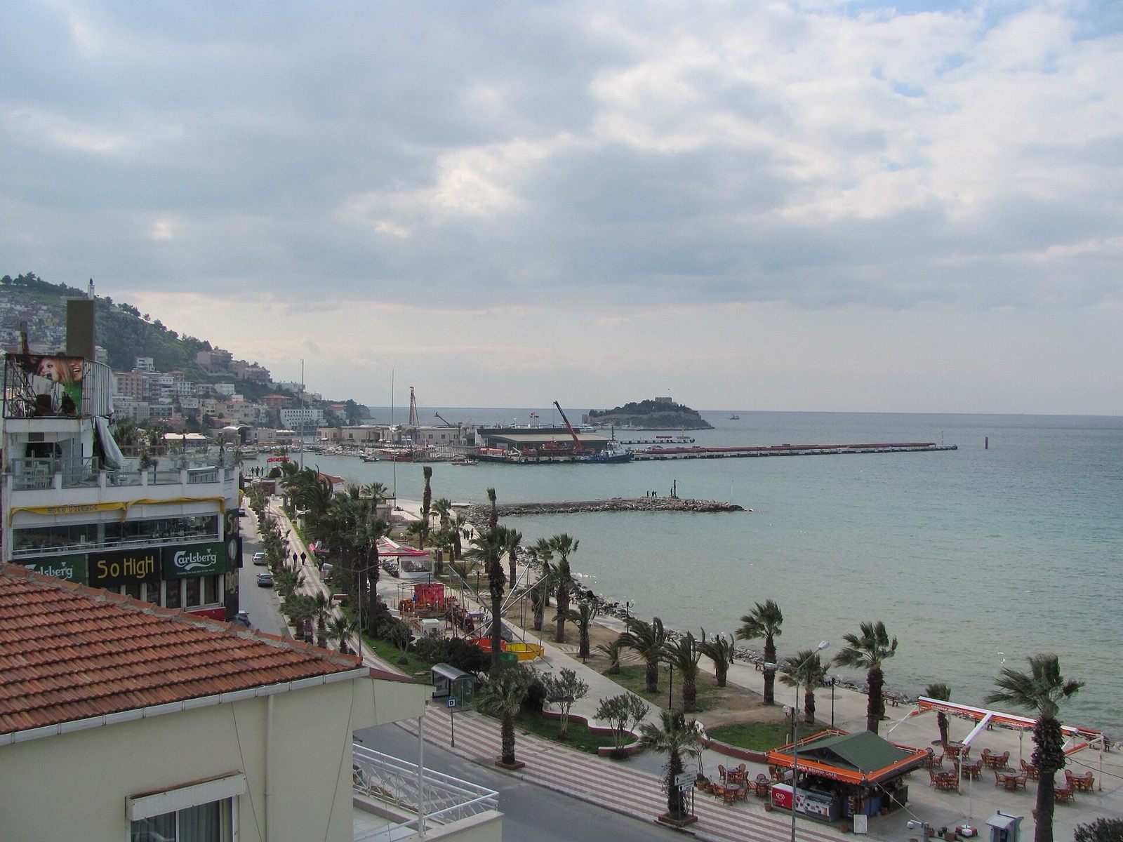 Kuşadası kordonu, palmiyeler ve uzakta Güvercinada
